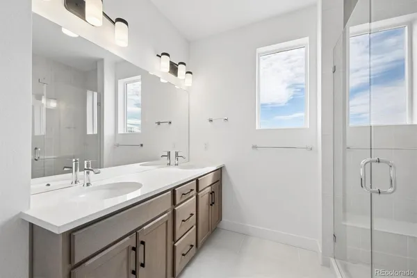 a bathroom with a sink double vanity and shower