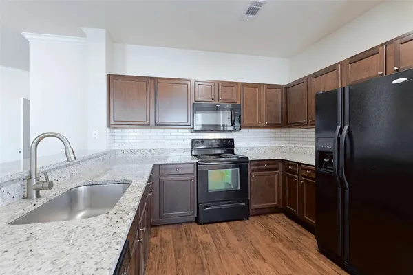 a kitchen with stainless steel appliances granite countertop a sink stove and refrigerator