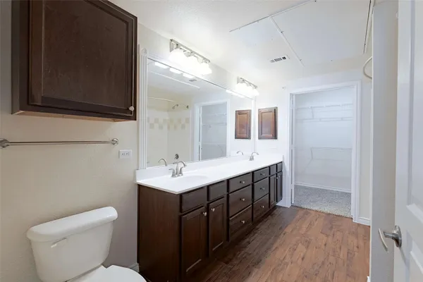 a bathroom with a double vanity sink mirror and toilet