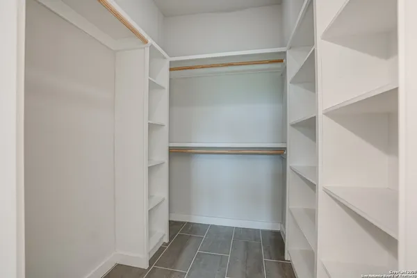 a view of walk in closet with empty racks