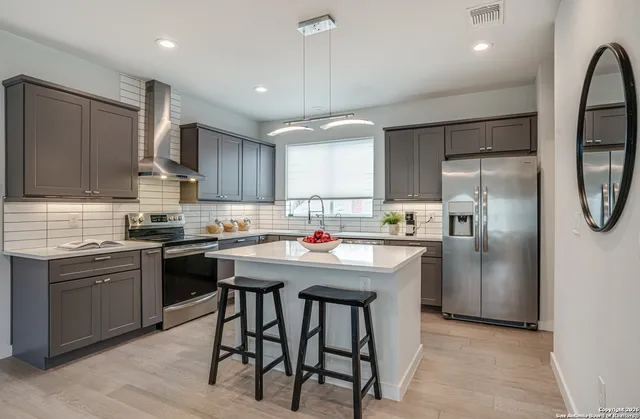 a kitchen with stainless steel appliances granite countertop a stove refrigerator sink and cabinets