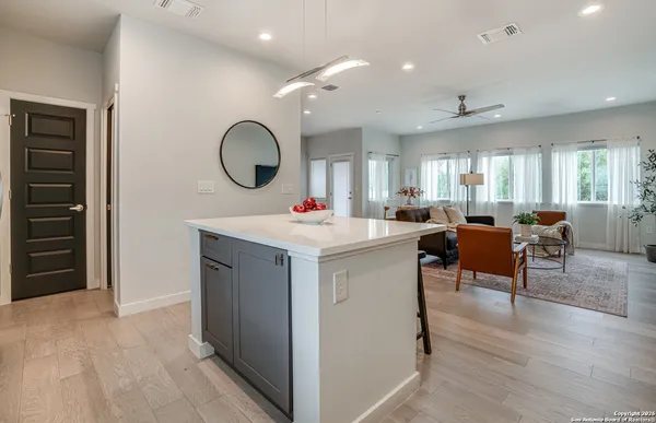 a living room with furniture a mirror and white walls