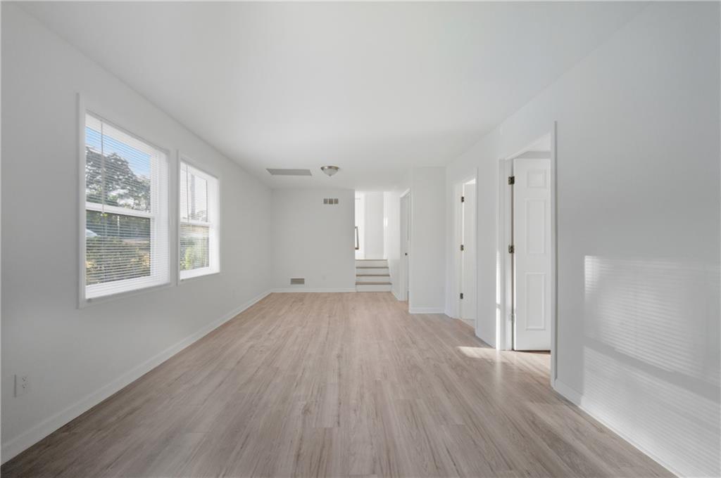 4974 Browns Mill Road Lithonia, GA 30038 - Photo 15 of 18 a view of an empty room with wooden floor and a window