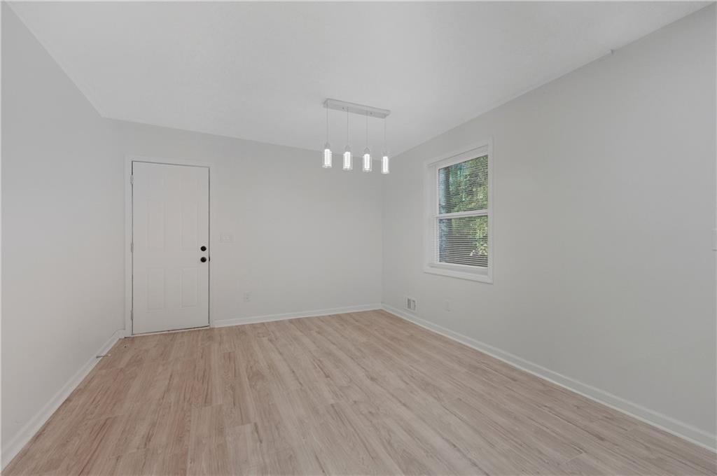 4974 Browns Mill Road Lithonia, GA 30038 - Photo 4 of 18 a view of an empty room with wooden floor and a window