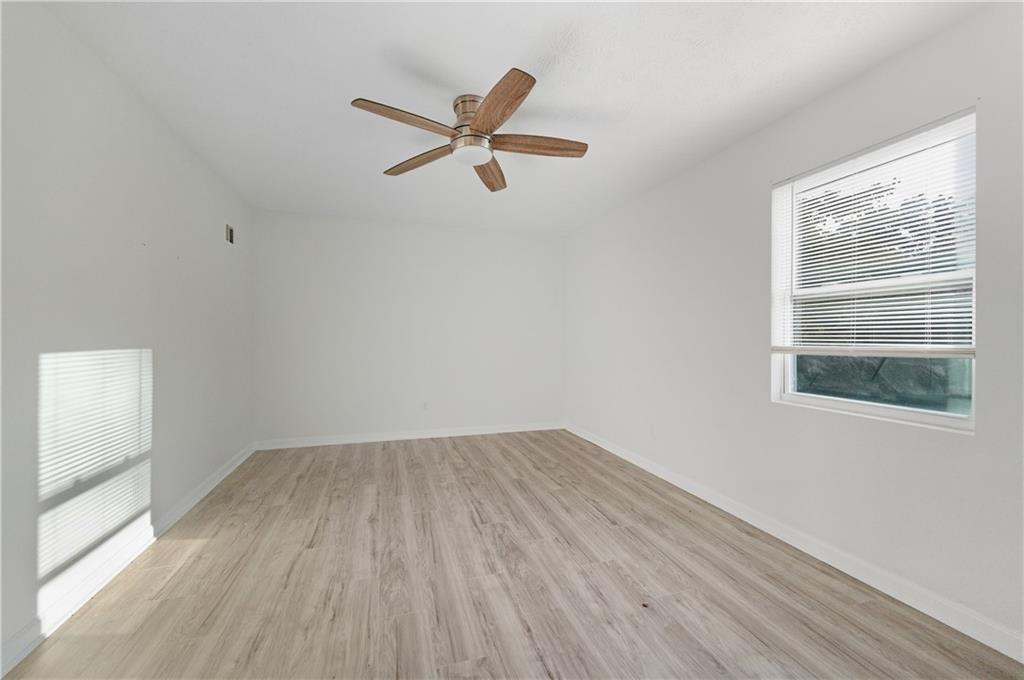 4974 Browns Mill Road Lithonia, GA 30038 - Photo 7 of 18 a view of empty room with wooden floor and fan