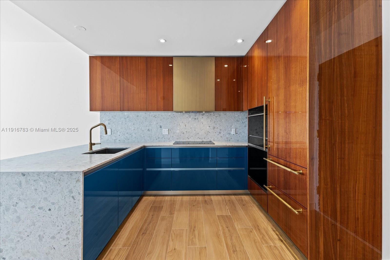 2678 Tigertail Avenue, Unit 1605 Miami, FL 33133 - Photo 4 of 17 a kitchen with a sink and wooden cabinet