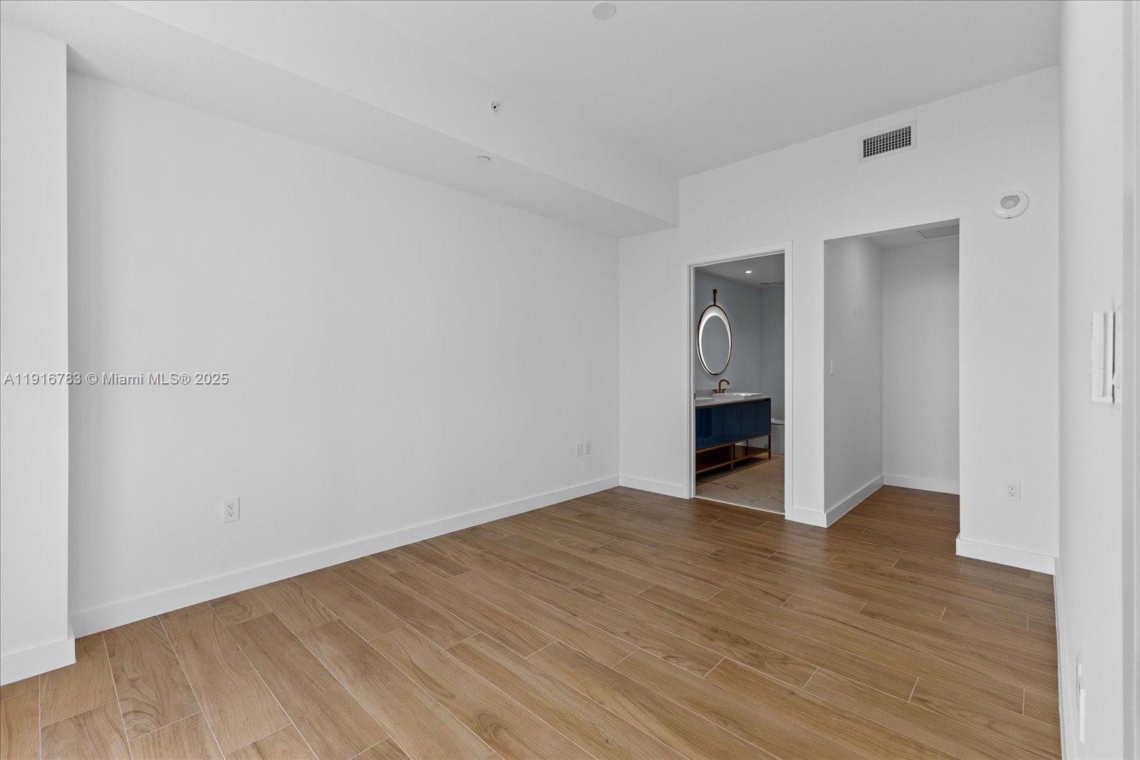 2678 Tigertail Avenue, Unit 1605 Miami, FL 33133 - Photo 6 of 17 a view of an empty room with wooden floor and a window