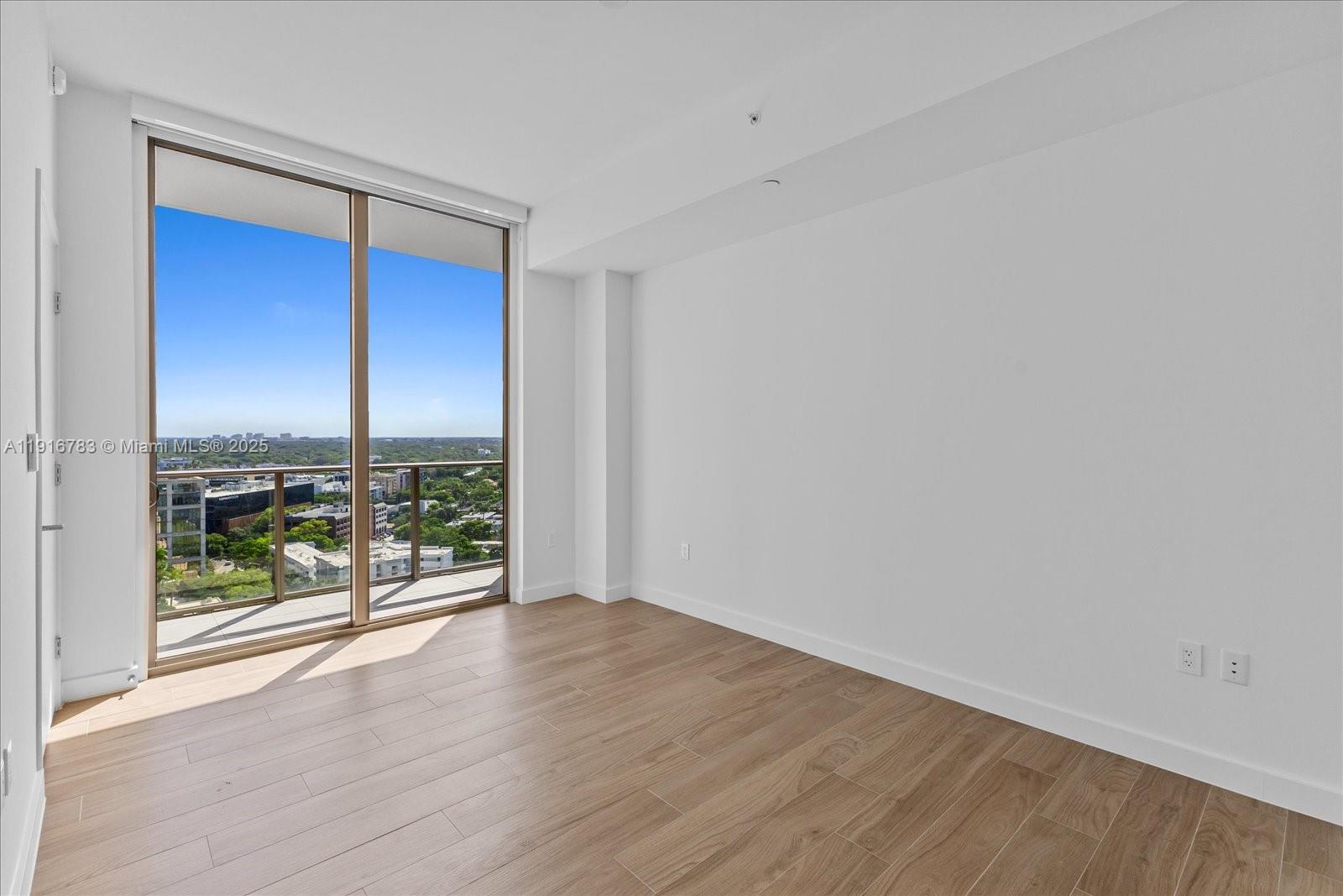 2678 Tigertail Avenue, Unit 1605 Miami, FL 33133 - Photo 8 of 17 an empty room with wooden floor and windows