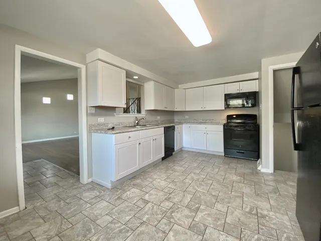 a kitchen with stainless steel appliances granite countertop a refrigerator sink and cabinets