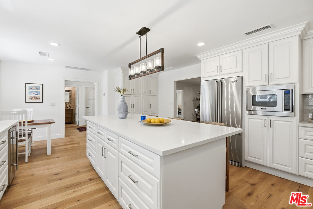 10 Baymare Road Bell Canyon, CA 91307 - Photo 11 of 54 a kitchen with white cabinets and stainless steel appliances