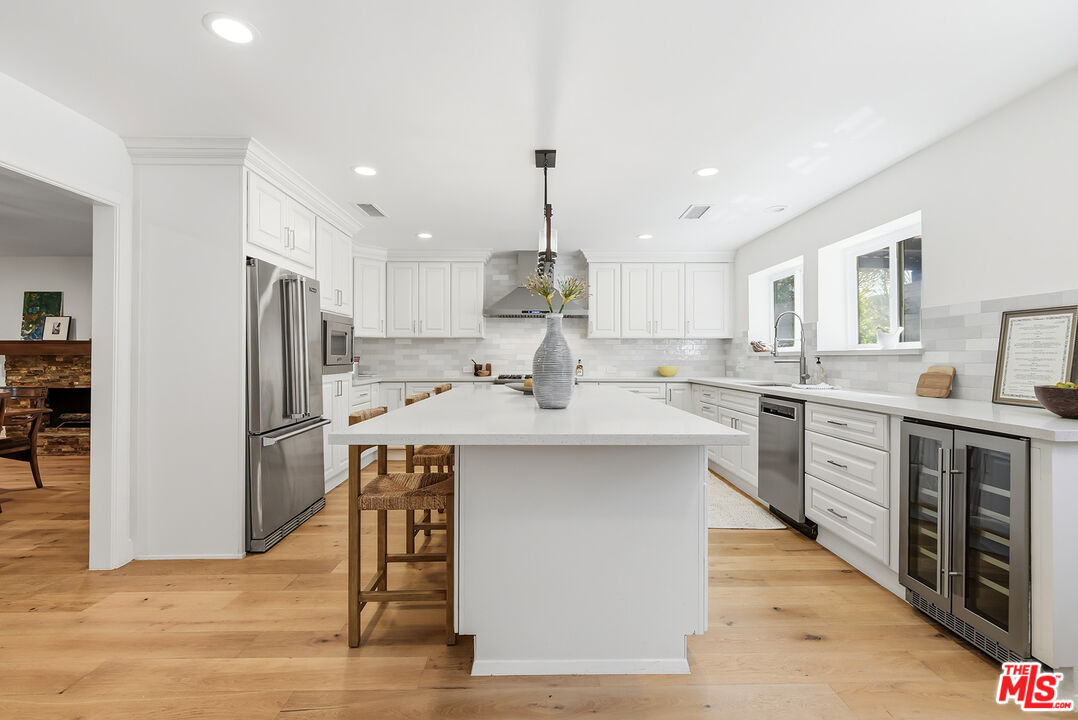 10 Baymare Road Bell Canyon, CA 91307 - Photo 8 of 54 a kitchen with kitchen island granite countertop a stove a sink dishwasher a refrigerator and white cabinets with wooden floor