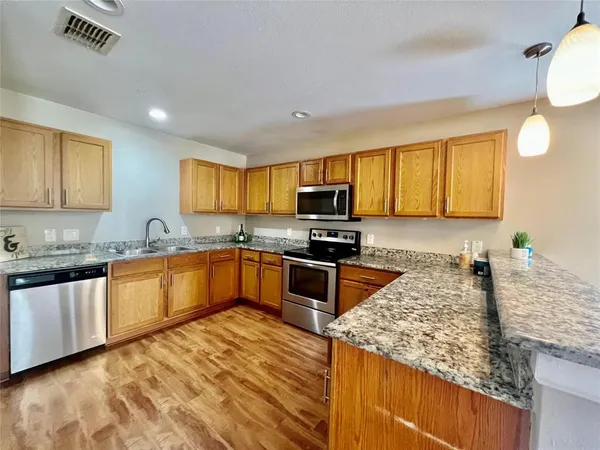 a kitchen with stainless steel appliances granite countertop a sink stove and refrigerator