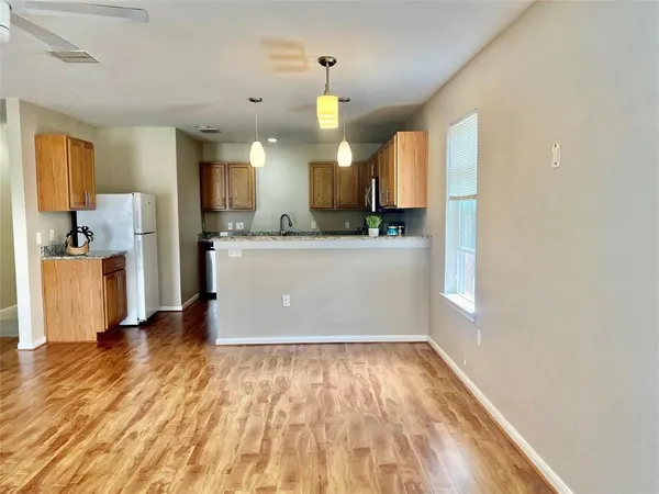 a view of a kitchen with a sink and a refrigerator