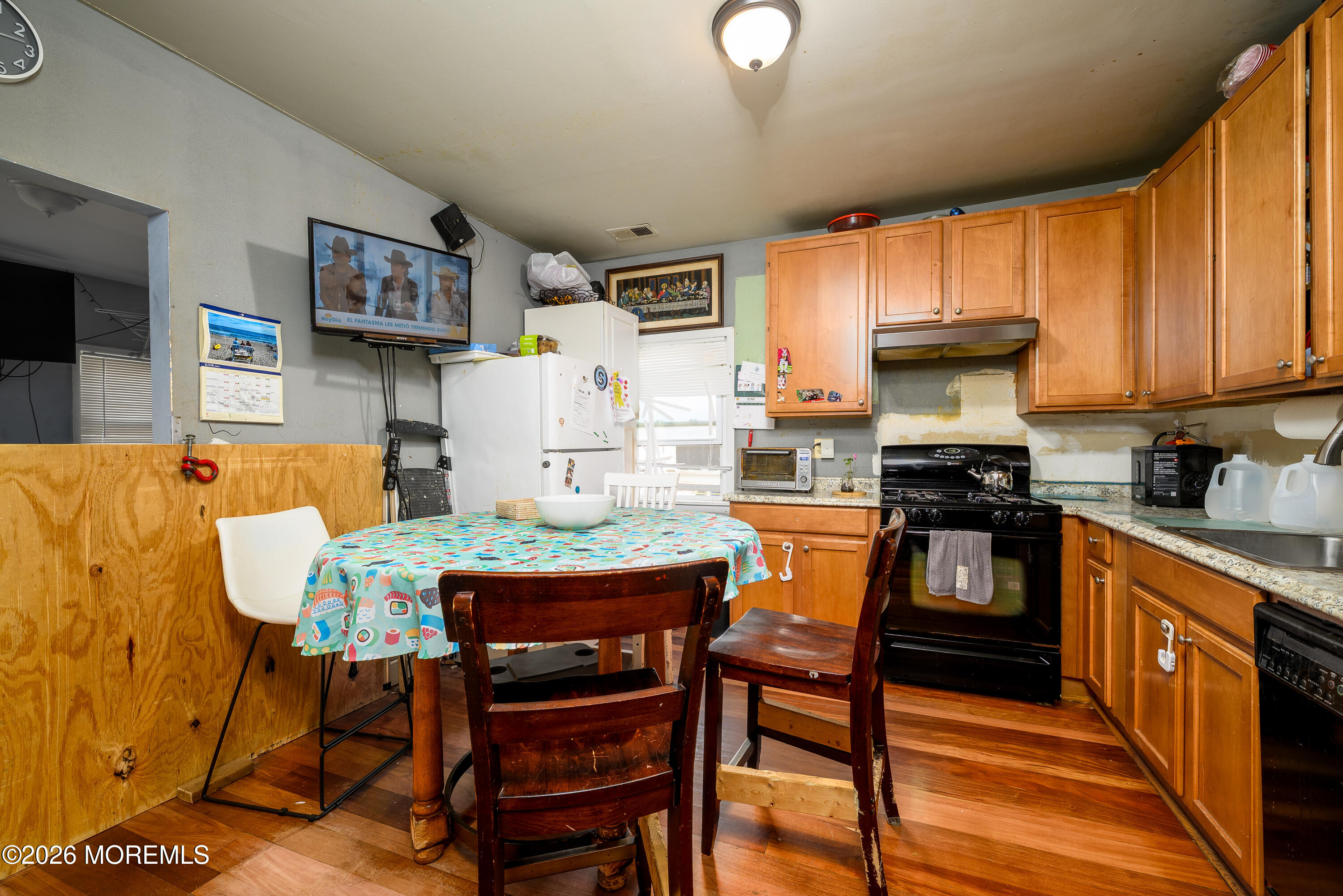 2nd Avenue, Unit 2 Long Branch, NJ 07740 - Photo 7 of 32 a kitchen with stainless steel appliances kitchen island granite countertop a dining table chairs and a refrigerator