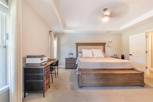 a large white bathroom with a granite countertop sink a toilet a shower and a mirror