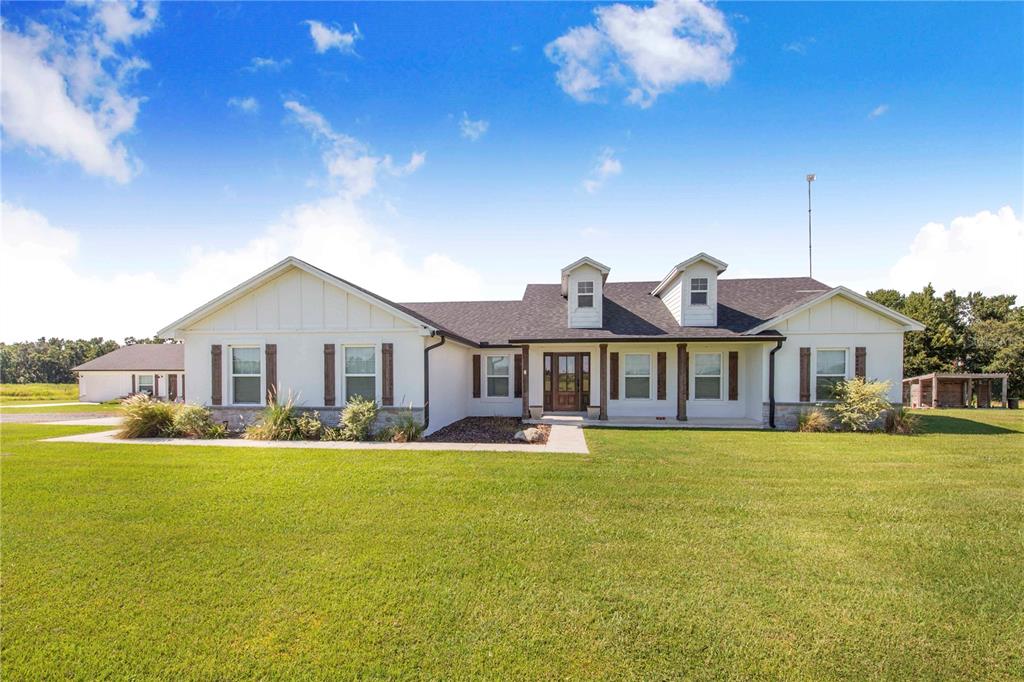 705 Brook Road North Fort Meade, FL 33841 - Photo 3 of 54 a view of a house with a big yard and large trees