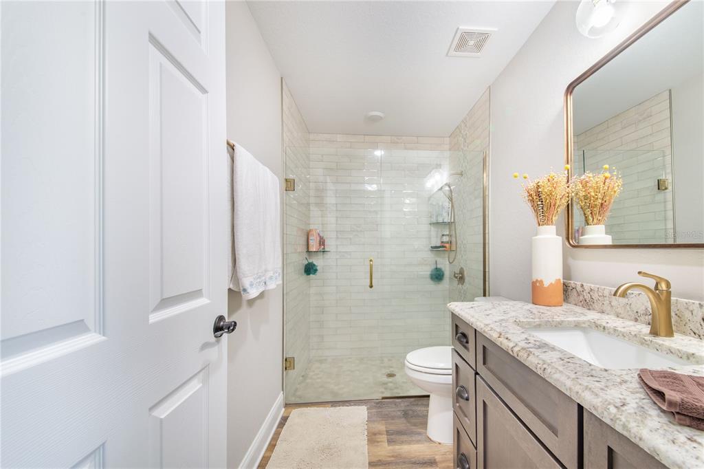 705 Brook Road North Fort Meade, FL 33841 - Photo 40 of 54 a bathroom with a granite countertop sink a toilet a mirror and shower