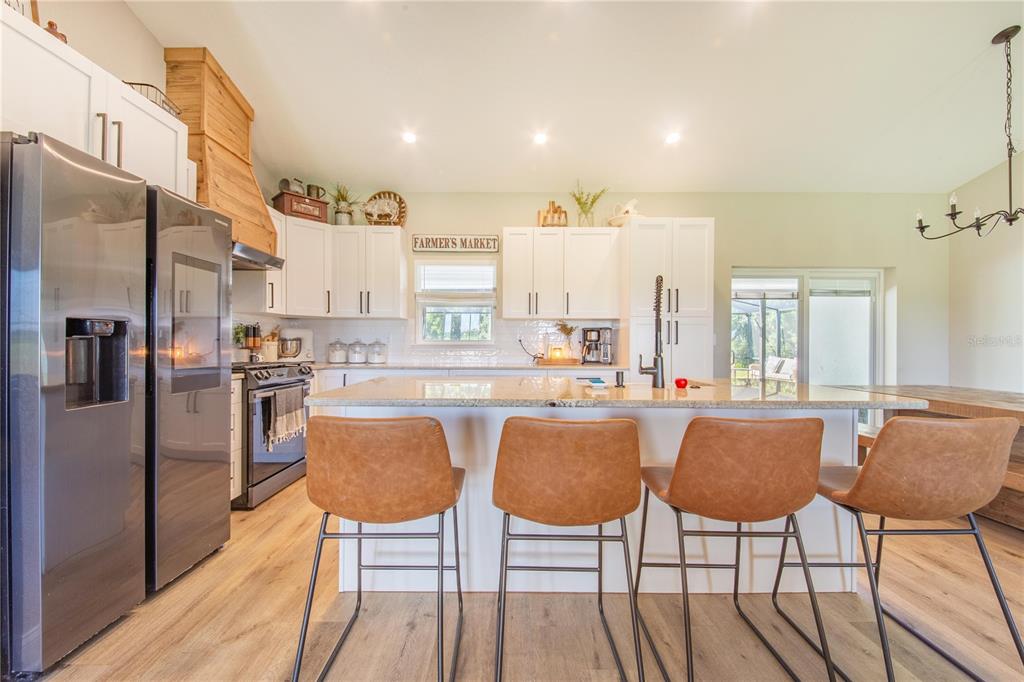 705 Brook Road North Fort Meade, FL 33841 - Photo 7 of 54 a kitchen with stainless steel appliances granite countertop a dining table chairs and granite counter tops