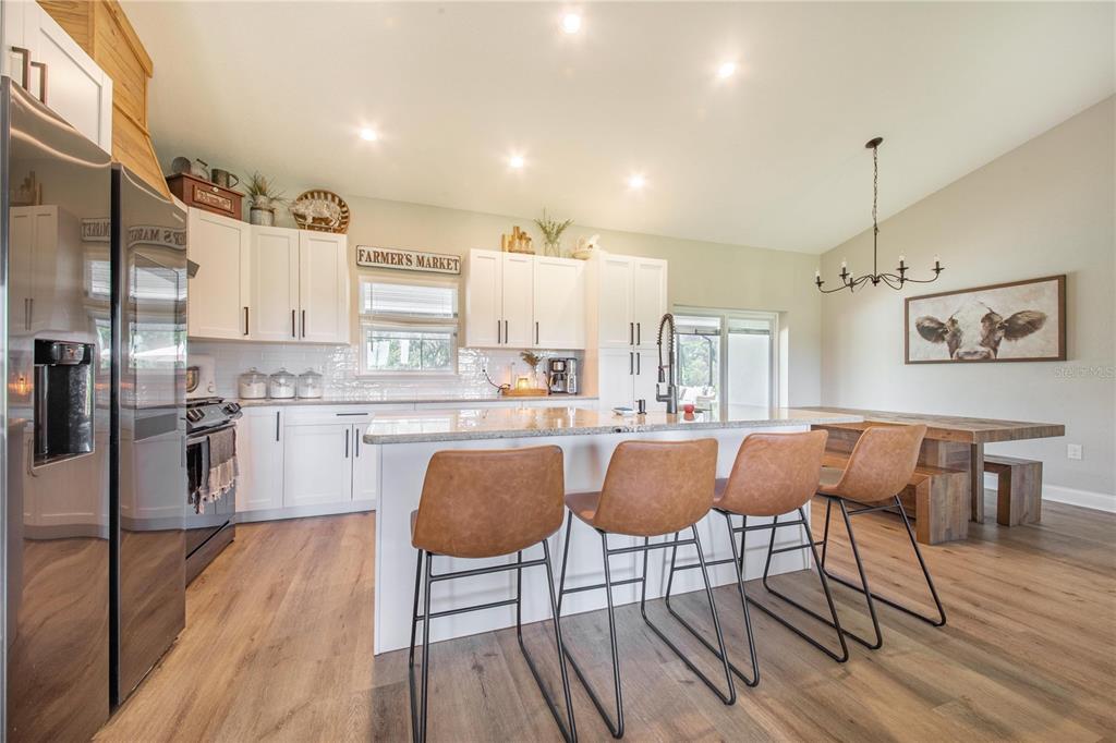 705 Brook Road North Fort Meade, FL 33841 - Photo 10 of 54 a kitchen with stainless steel appliances granite countertop a dining table chairs refrigerator and sink