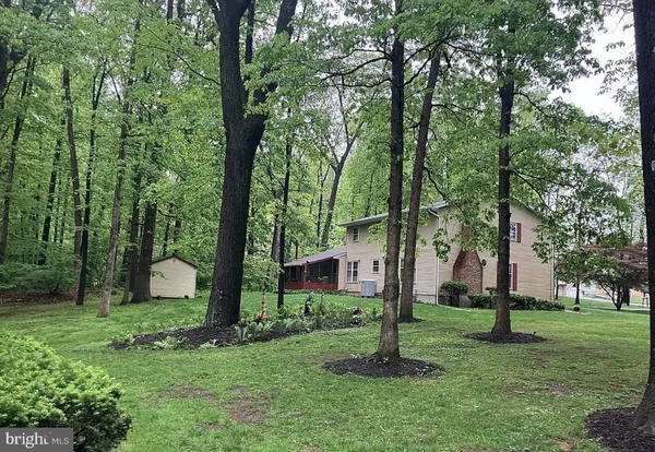 a view of a house with backyard and trees