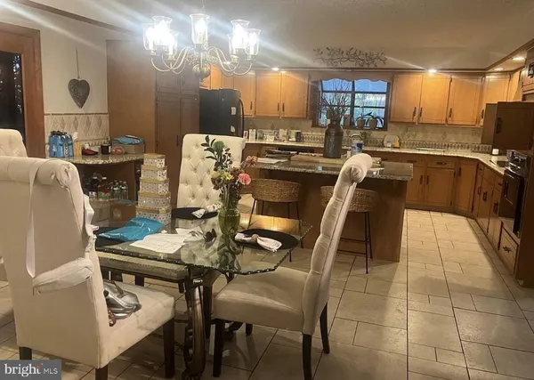 a kitchen with a table chairs microwave and cabinets