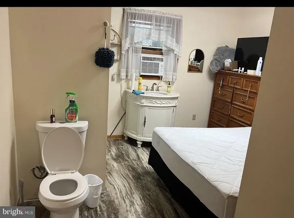 a bathroom with a toilet a sink and a mirror