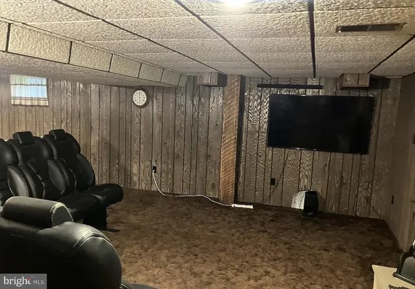 a living room with furniture a flat screen tv and a window