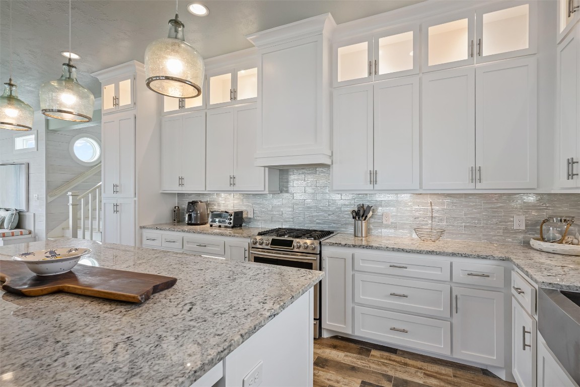3116 James Street Crystal Beach, TX 77650 - Photo 16 of 47 a kitchen with granite countertop a sink a stove and cabinets