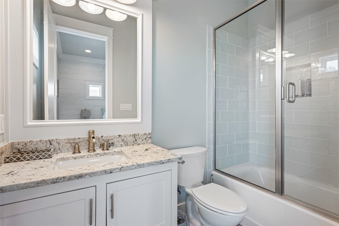 3116 James Street Crystal Beach, TX 77650 - Photo 27 of 47 a bathroom with a granite countertop sink toilet and shower glass cabinet