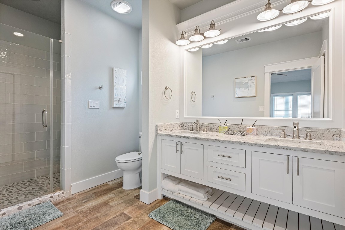 3116 James Street Crystal Beach, TX 77650 - Photo 32 of 47 a bathroom with a granite countertop double vanity sink a mirror and a toilet
