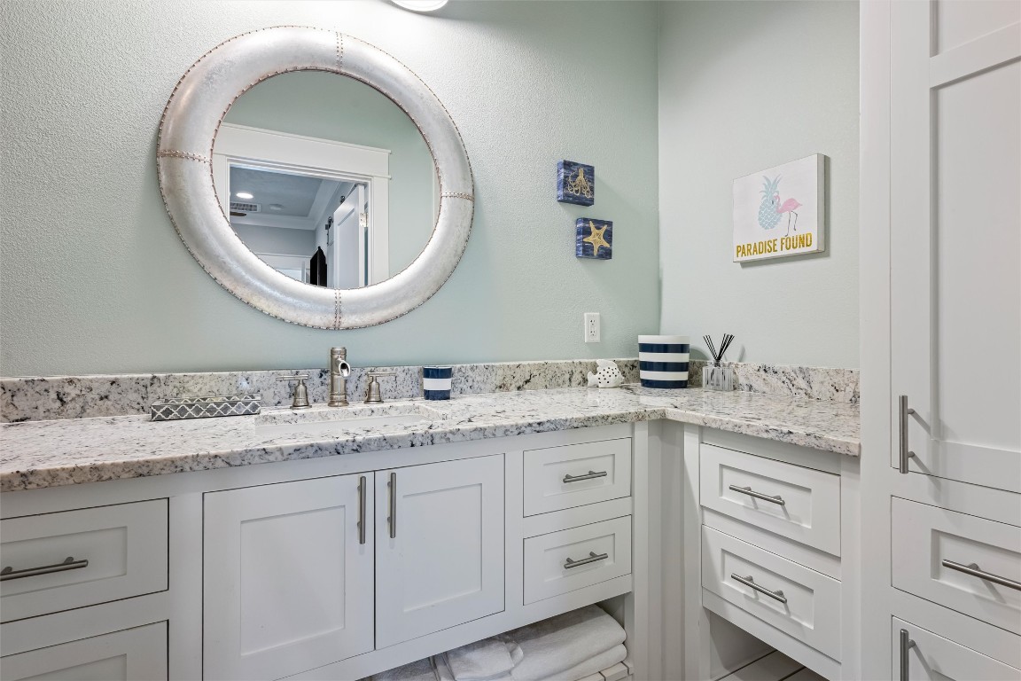 3116 James Street Crystal Beach, TX 77650 - Photo 37 of 47 a bathroom with a granite countertop toilet sink and mirror