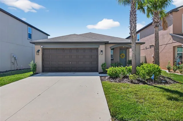 a front view of a house with a yard and garage