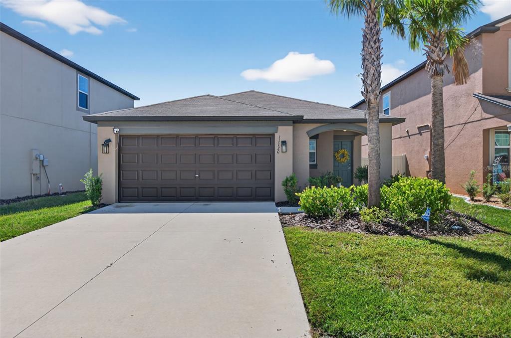 11120 Radiant Shore Loop San Antonio, FL 33576 - Photo 1 of 17 a front view of a house with a yard and garage