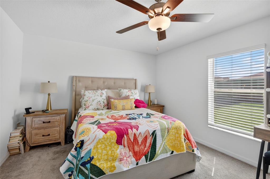 11120 Radiant Shore Loop San Antonio, FL 33576 - Photo 15 of 17 a bedroom with a bed and a chandelier