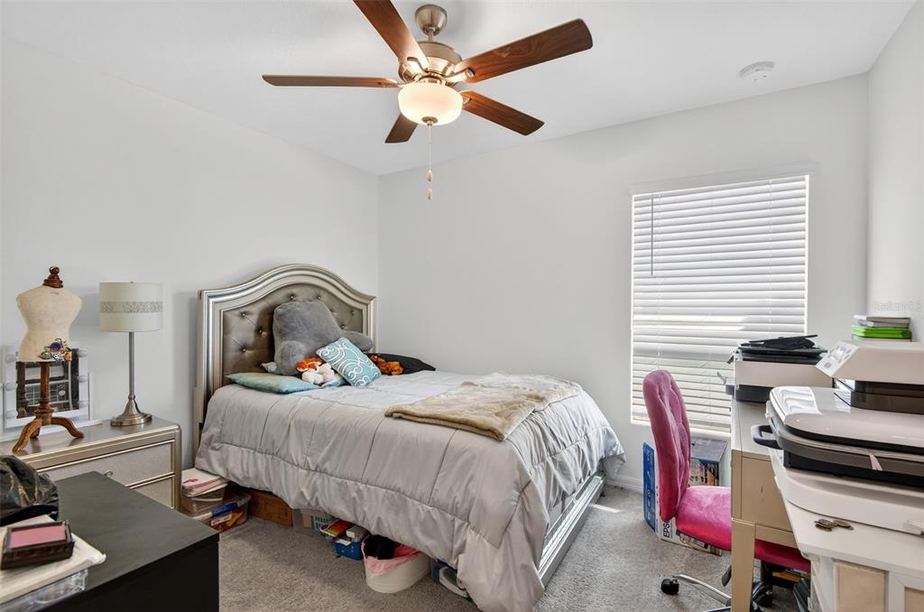 11120 Radiant Shore Loop San Antonio, FL 33576 - Photo 4 of 17 a bedroom with a bed and a chandelier