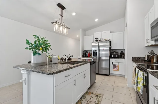 a kitchen with stainless steel appliances granite countertop a sink dishwasher stove and refrigerator