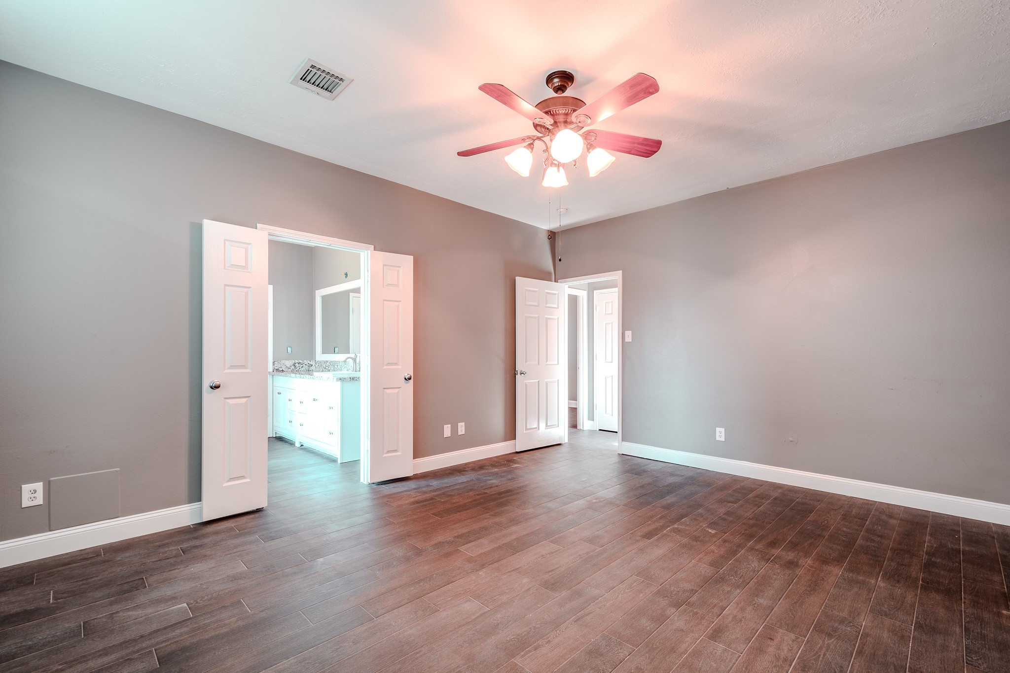 8515 Holly Spring Lane Baytown, TX 77523 - Photo 16 of 28 an empty room with wooden floor chandelier fan and windows