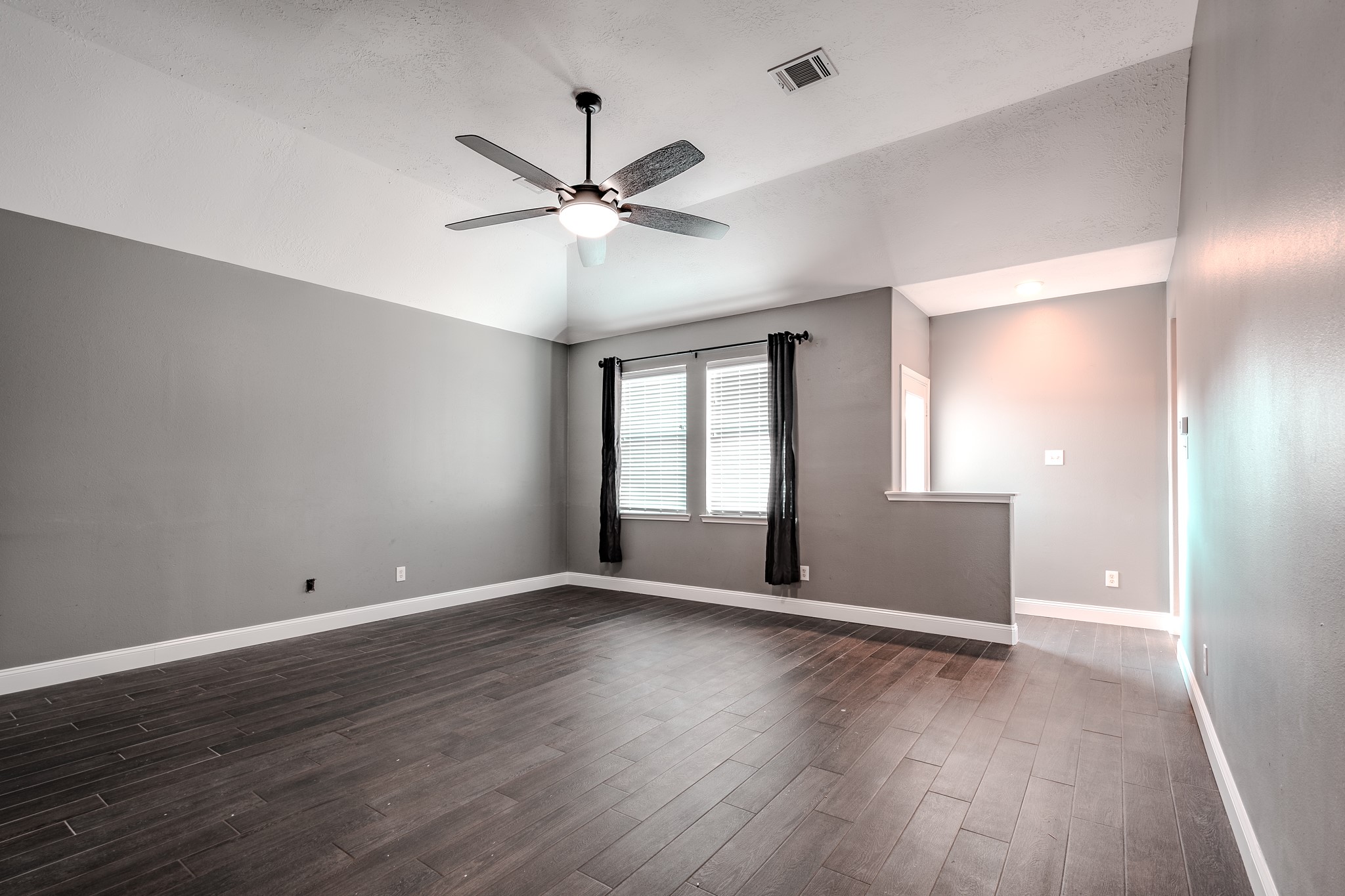 8515 Holly Spring Lane Baytown, TX 77523 - Photo 10 of 28 a view of an empty room with wooden floor and a window