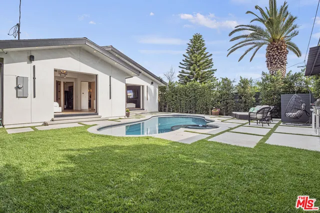 a view of a house with swimming pool and sitting area