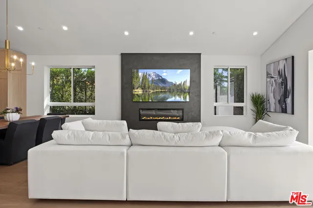 a living room with furniture a large window and a flat screen tv