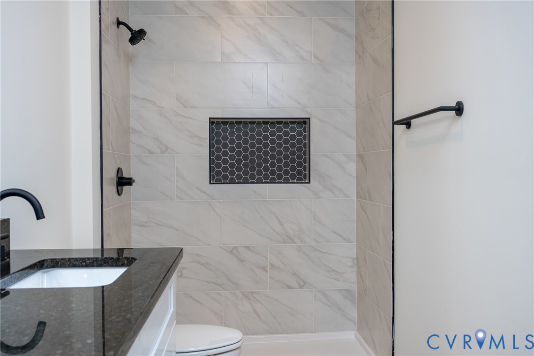 601 Mill Pond Drive Ruther Glen, VA 22546 - Photo 22 of 32 a bathroom with a granite countertop sink a toilet and shower