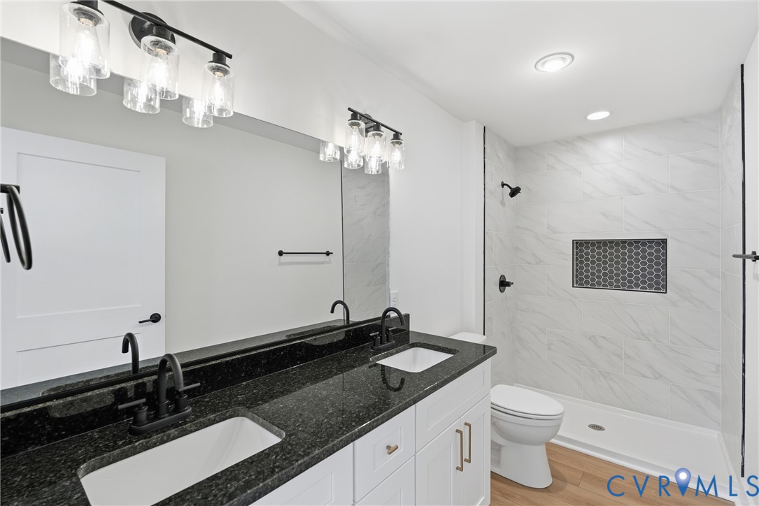 601 Mill Pond Drive Ruther Glen, VA 22546 - Photo 24 of 32 a bathroom with a granite countertop sink a toilet a mirror and shower