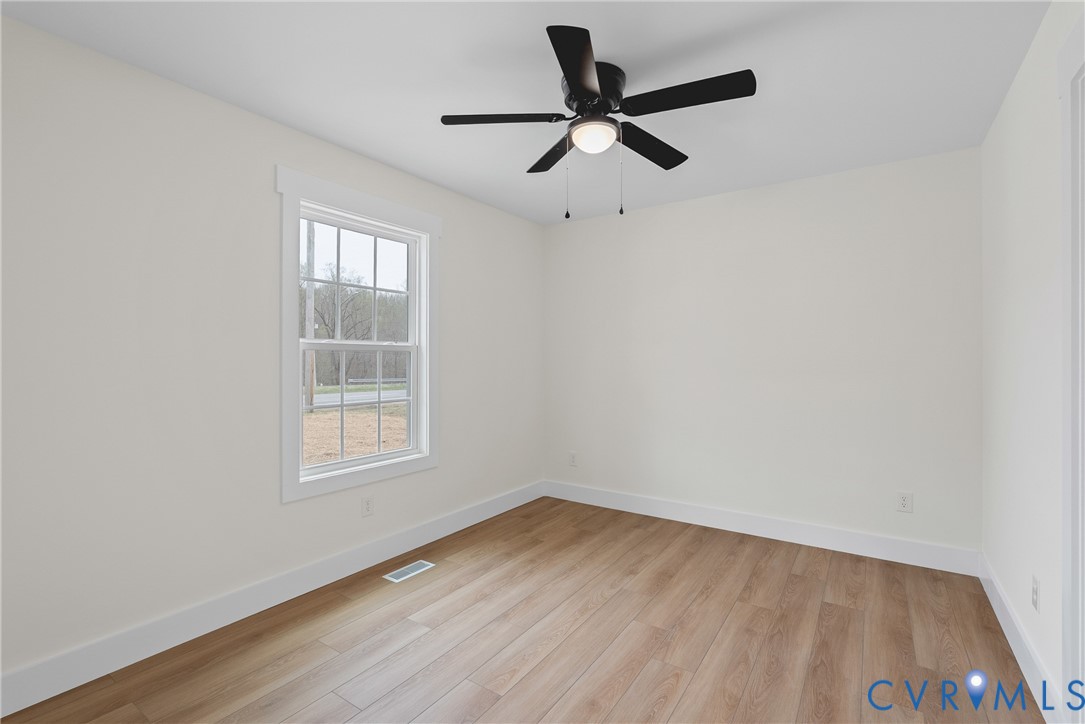 601 Mill Pond Drive Ruther Glen, VA 22546 - Photo 29 of 32 an empty room with wooden floor and windows