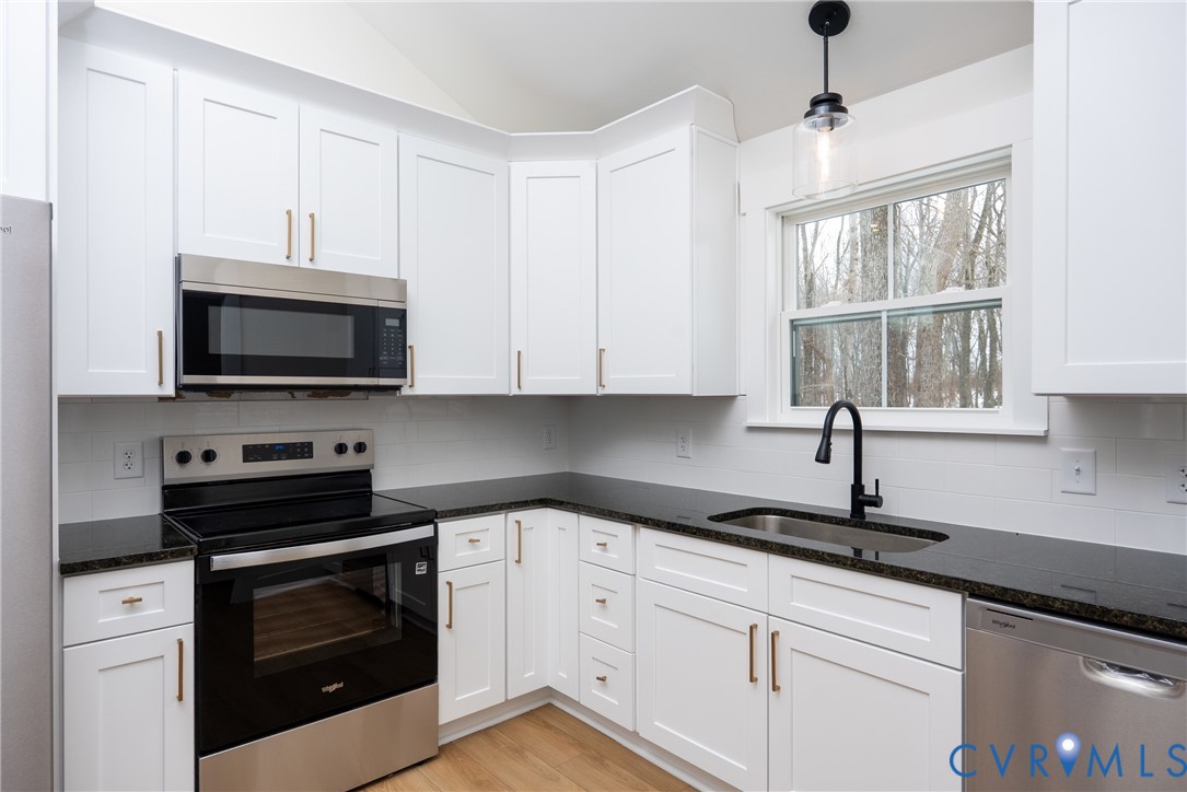601 Mill Pond Drive Ruther Glen, VA 22546 - Photo 7 of 32 a kitchen with white cabinets and appliances
