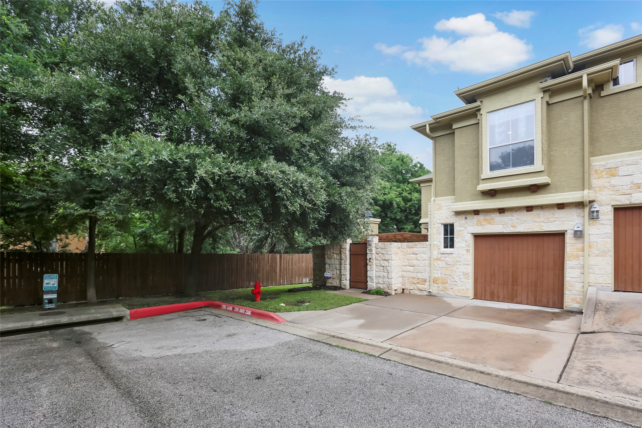 3406 Menchaca Road, Unit 19 Austin, TX 78704 - Photo 2 of 25 Mature trees shade the driveway and stone-accented facade of this contemporary multi-level townhome.