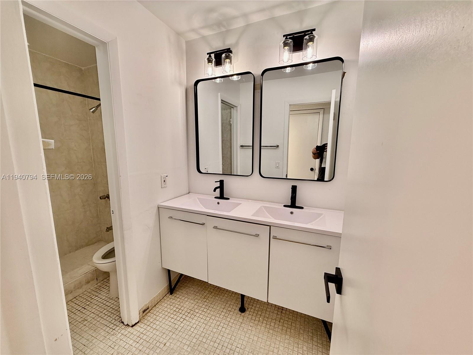 617 Northwest 10th Street Miami, FL 33136 - Photo 11 of 29 a bathroom with a double vanity sink toilet and mirror