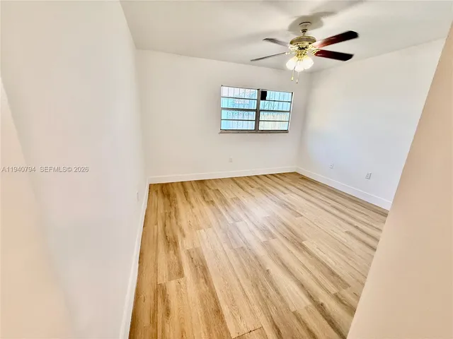 a view of an empty room with a ceiling fan