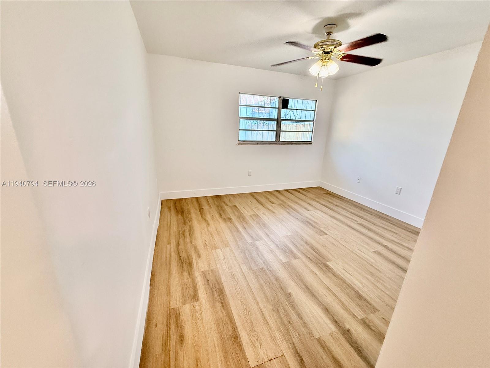 617 Northwest 10th Street Miami, FL 33136 - Photo 13 of 29 an empty room with windows and ceiling fan