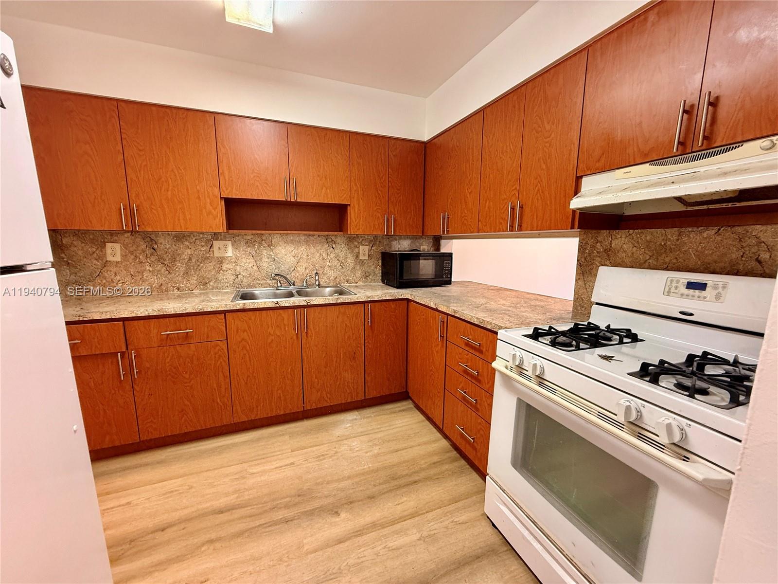 617 Northwest 10th Street Miami, FL 33136 - Photo 9 of 29 a kitchen with stainless steel appliances granite countertop a stove a sink and a microwave