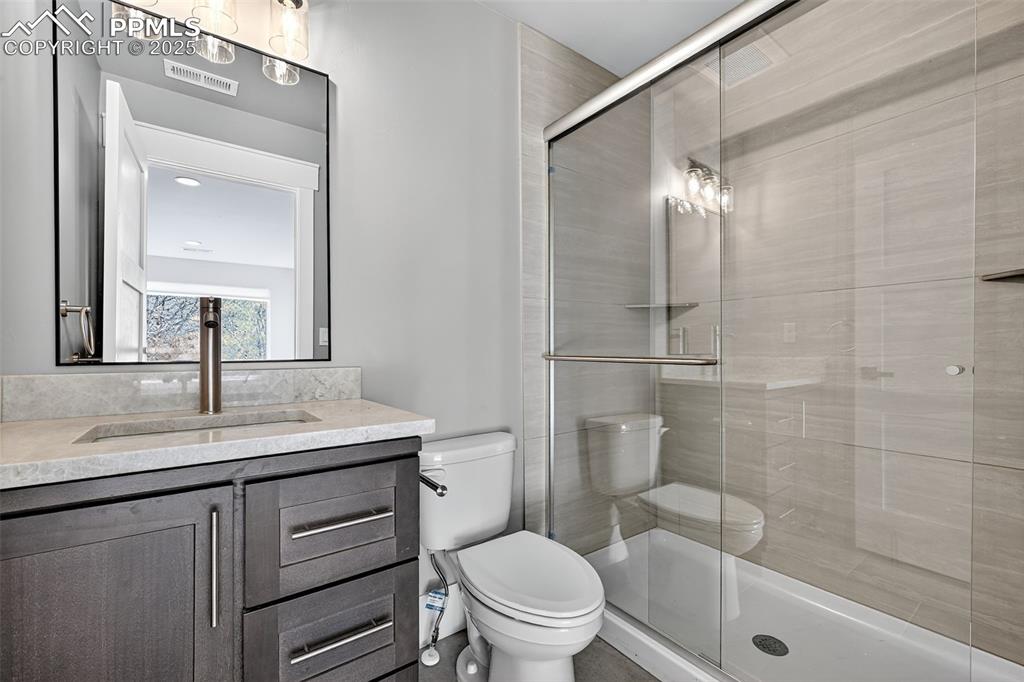 485 Cardiff Circle Colorado Springs, CO 80906 - Photo 25 of 50 a bathroom with a granite countertop sink toilet and shower